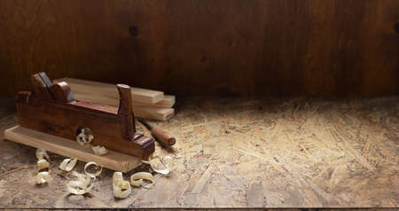 Woodworking tools on wooden table. Plane jointer carpenter or joiner tool and wooden shavings....