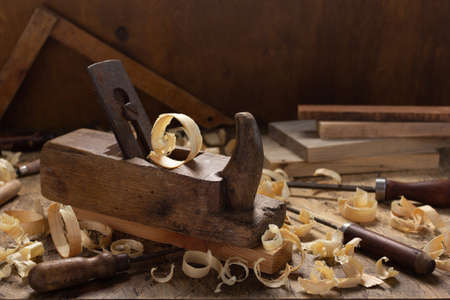 Woodworking tools on wooden table. Plane jointer carpenter or joiner tool and wooden shavings. Carpentry workshopの写真素材