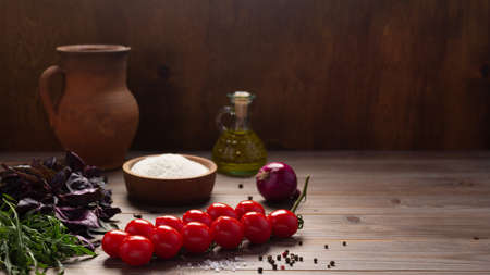Food ingredients for pizza cooking and tomato with spice for homemade bread baking on table. Spice and herb at wooden tabletop background. Bakery concept in kitchenの写真素材