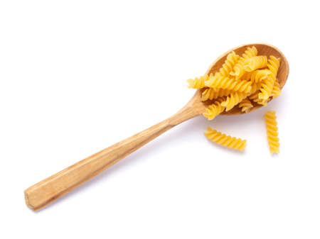 Raw pasta in spoon isolated on white. Pasta fusilli at white backgroundの写真素材