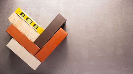 Construction brick and level at cement background. Brick  wall texture or floorの写真素材
