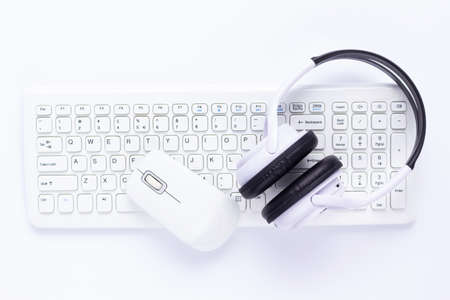 Wireless headphones, computer keyboard and mouse on white background