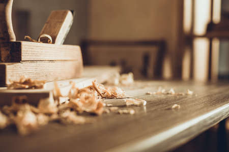 Plane jointer carpenter or joiner tool and wood shavings. Woodworking tools on wooden table. Carpentry workshopの写真素材