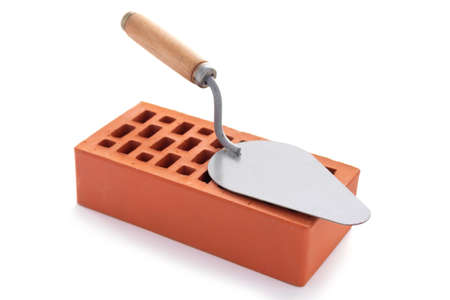 Clay brick and trowel tool isolated on white background. Construction brick with mason at whiteの写真素材
