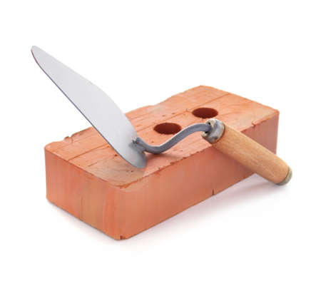 Clay brick and trowel tool isolated on white background. Construction brick with mason at whiteの写真素材