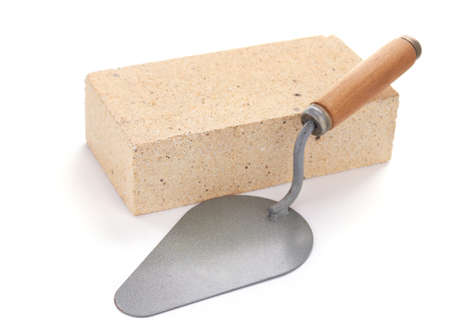 Cement brick and trowel tool isolated on white background. Construction brick with mason at whiteの写真素材