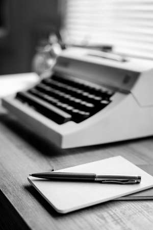 Pen and notepad with vintage typewriter at wood desk table. Writer or study creative conceptの写真素材