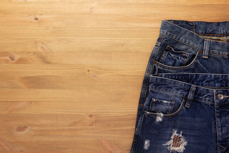 Blue jeans denim pocket on wood table. Jeans heap at wooden background textureの写真素材