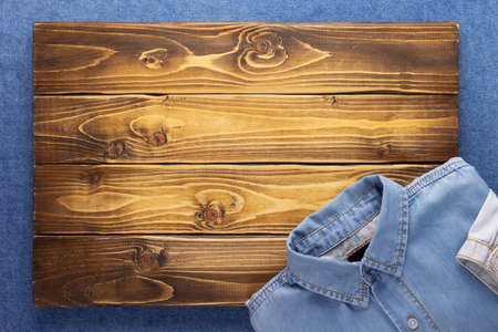 Blue jeans denim and wood background texture. Jeans material with plank wooden boardの写真素材