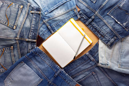 Notebook and blue jeans denim pocket background texture. Jeans stack heapの写真素材