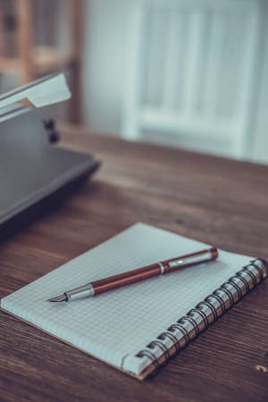 Writer or screenwriter creative concept. Notebook and vintage old typewriter at wooden desk tableの写真素材