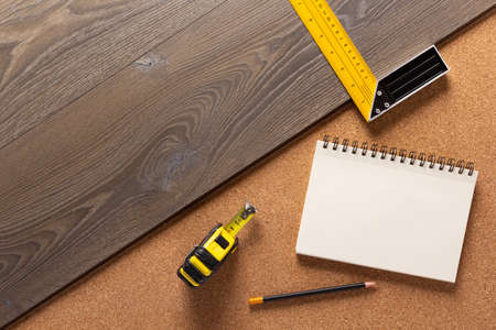 Wood laminate and tools at floor background texture. Wooden laminate top view