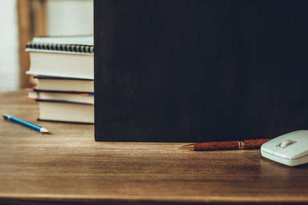 Chalkboard and school supplies at table. Student home workplace