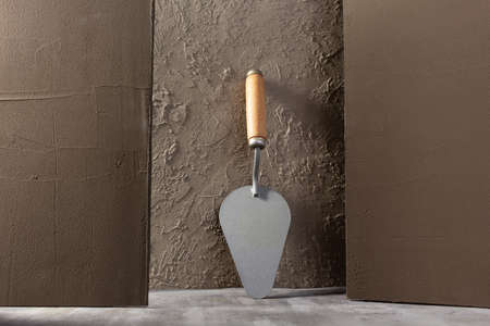 Concrete wall and construction trowel tool. Construction concept and masonの写真素材