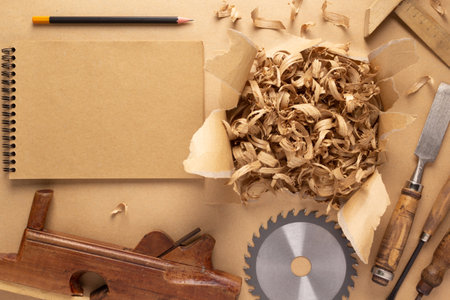 Plane jointer carpenter or joiner tool and wood shavings. Torn paper and woodworking tools at wooden tableの写真素材