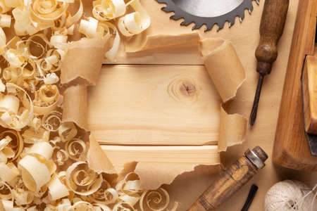 Plane jointer carpenter or joiner tool and wood shavings. Torn paper and woodworking tools at wooden...