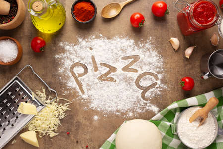 Pizza and flour homemade cooking or baking on table. Pizza ingredient at tabletop background top view. Recipe concept in kitchenの写真素材