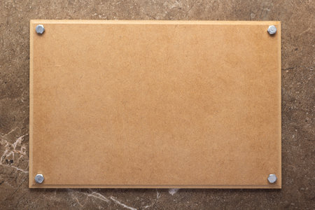 Wooden nameplate or sign board screwed on wall background. Front view of name plateの写真素材