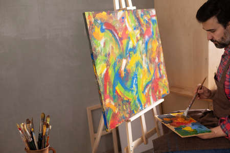 Male artist working on painting. Man artist painter and palettte in creative studio as art conceptの写真素材