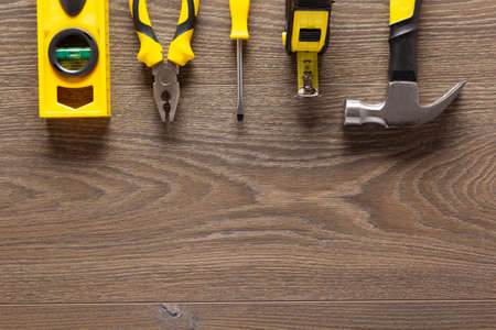Construction tools at wood laminate floor background texture. Wooden laminate top viewの写真素材