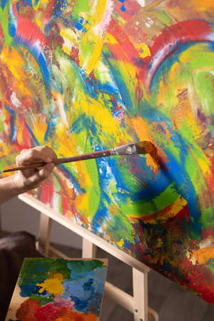Artist working on painting. Painter hand and brush in creative studio as art conceptの写真素材