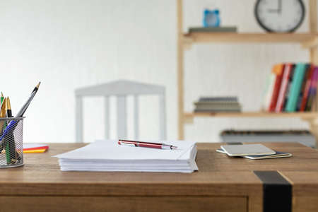 Sheet of paper on wooden desk table. Office or study creative conceptの写真素材