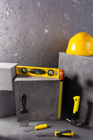 Construction tools and concrete cube  at brick on abstract background texture. Art or construction...