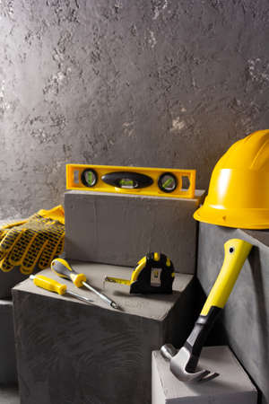 Construction tools and concrete cube  at brick on abstract background texture. Art or construction conceptの写真素材