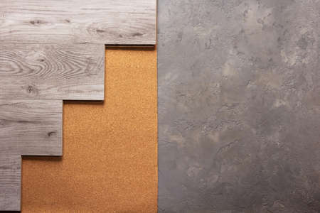 Laminate wood floor on cork background texture. Wooden laminate floor and corkboard at cement with copy spaceの写真素材