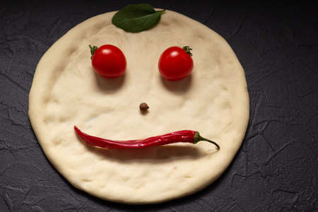 Pizza dough and ingredients for homemade cooking at table. Recipe concept in kitchenの写真素材