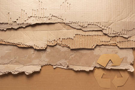 Recycle symbol at cardboard paper as background texture. Recycling concept and brown paperの写真素材