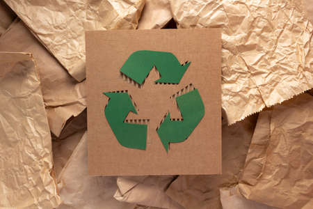 Recycle symbol at cardboard paper as background texture. Recycling idea concept and brown paperの写真素材
