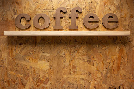 coffee letters on chipboard plywood background textureの写真素材