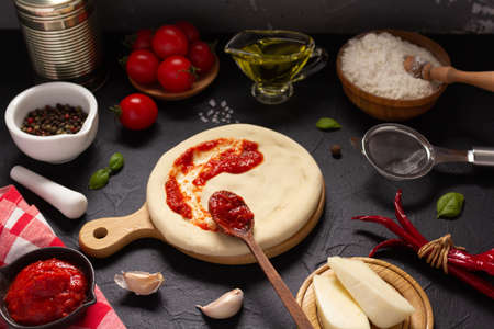 Pizza and sauce with ingredients at table. Pizza cooking on tabletop backgroundの写真素材