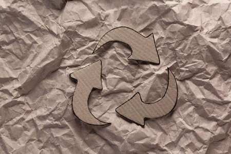 Recycle symbol at  crumpled paper background texture. Recycling idea concept and cardboard paperの写真素材