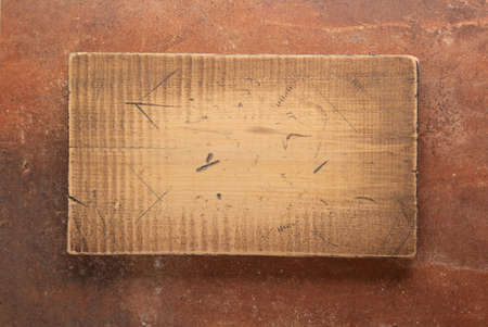 Wooden nameplate or sign board screwed on wall background. Front view of name plate