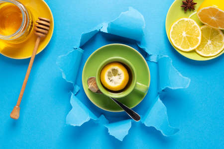 Cup of tea with lemon and honey in torn paper. Mug full of teaの写真素材