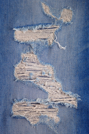 Torn jeans denim background texture. Blue Jeans fabric as material surfaceの写真素材
