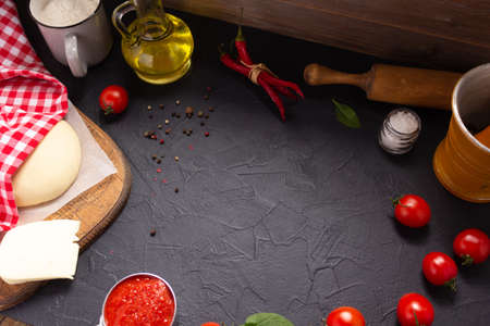 Pizza or dough for bread with ingredients at table. Pizza recipe homemade on tabletop backgroundの写真素材