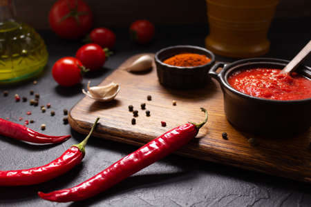 Chilly pepper and tomato sauce ingredient for homemade cooking on table. Chilli and recipe concept in kitchenの写真素材