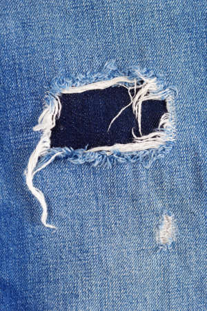 Torn jeans denim background texture. Blue Jeans fabric as material surfaceの写真素材