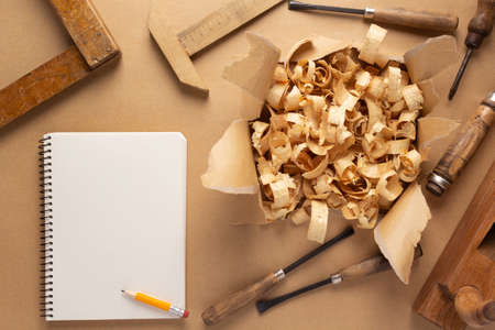 Woodworking carpenter chisel tool and wood shavings  on paper background. Chisel as joiner toolの写真素材