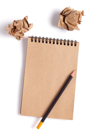 Sketchbook and crumpled paper balls at isolated white background. Inspiration creative idea conceptの写真素材