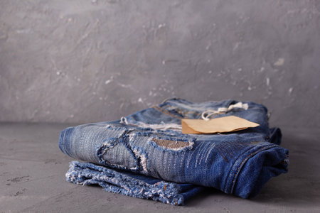 Paper price tag label at jeans background texture. Blue jeans denim fabric