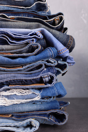 Blue jeans denim heap at table background. Jeans fabric stack as material surfaceの写真素材