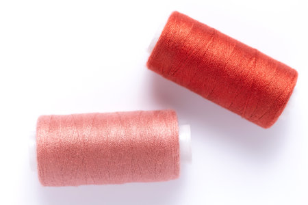 Sewing thread spool at white background, top view. Red spool with threadの写真素材