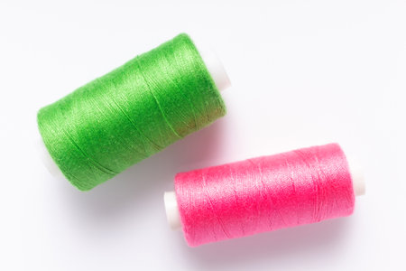 Sewing thread on spool at white background, top view. Bobbin with threadの写真素材
