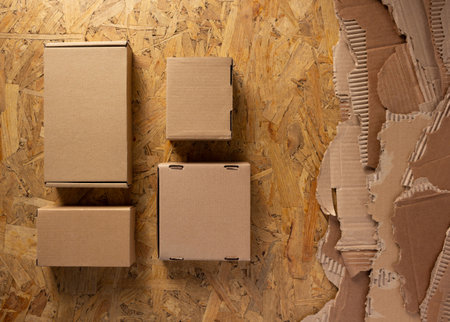 Cardboard box and torn waste paper at chipboard background texture. Recycling concept and brown...