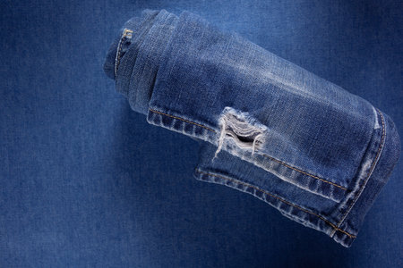 Folded blue jeans denim background texture. Jeans fabric as material surface