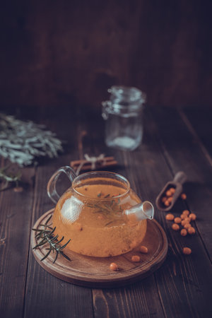 Teapot of sea ââââbuckthorn tea on wooden tableの写真素材